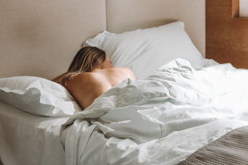 vrouw in bed met ontblote bovenrug