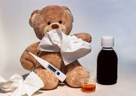 beer met zakdoek voor mond thermometer tussen zijn benen en een flesje medicijnen langs hem.
Ziet er ziek uit.