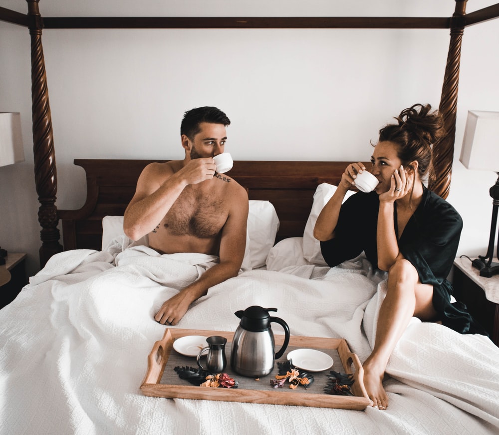 man en vrouw die in bed koffie drinken na de sex